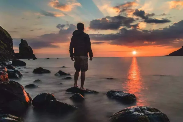 A man looking at a sunset while he evaluates his strength of character.